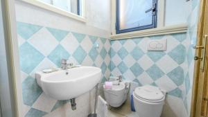 a bathroom with a sink and a toilet at House of Cherie in Leuca