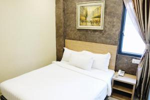 een hotelkamer met 2 bedden en een raam bij Era Plus Hotel in Seri Kembangan