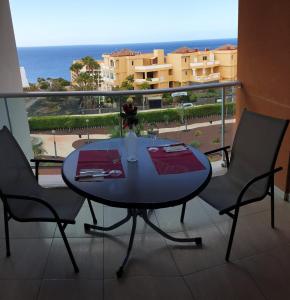 Una mesa y sillas en un balcón con vista al mar. en Appartamento Ocean View, en San Miguel de Abona