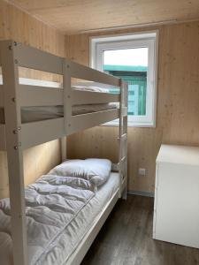 a bedroom with two bunk beds and a window at Naturcamping Lüneburger Heide - Chalets & Tiny Häuser in Soltau