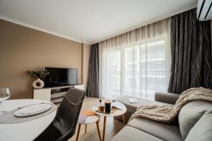 a living room with a couch and a table at Comfy luxury center apartment in Varna City