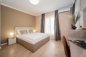 a bedroom with a large bed and a window at Comfy luxury center apartment in Varna City