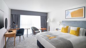 a hotel room with a large bed and a desk at voco Reading in Reading