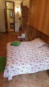 a bedroom with a bed with a flowered blanket on it at Monolocale l'Anfiteatro Romano in Assisi