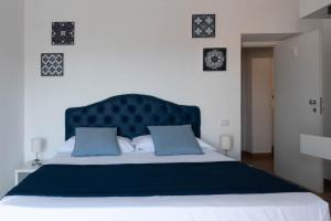 a bed with a blue headboard and two blue pillows at B&B Sirentum in Sorrento