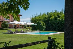 a swimming pool with chairs and umbrellas next to a house at Residence Regina dei Prati in Mason Vicento