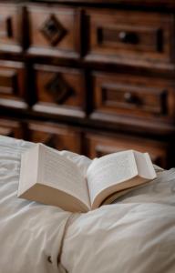an open book sitting on top of a bed at Casa Barbabuc in Novello
