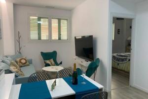 ein Wohnzimmer mit einem Sofa und einem Tisch mit Stühlen in der Unterkunft Apartamento Paseo de la Carihuela in Torremolinos