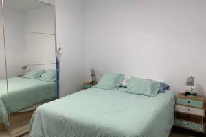 1 Schlafzimmer mit 2 Betten und einem Spiegel in der Unterkunft Apartamento Paseo de la Carihuela in Torremolinos