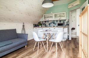 a living room with a couch and a table and chairs at Harmonia Apartman erkéllyel és SZAUNAval in Balatonfüred +2 photos