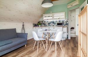 a living room with a couch and a table and chairs at Harmonia Apartman erkéllyel és SZAUNAval in Balatonfüred