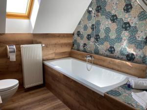 a bathroom with a bath tub and a toilet at Harmonia Apartman erkéllyel és SZAUNAval in Balatonfüred