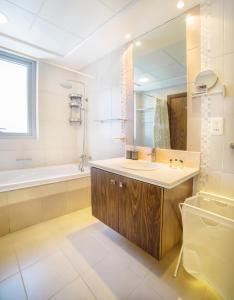 a bathroom with a sink and a tub and a mirror at New Large Apartment with Downtown View in Dubai