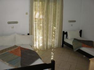 salon z 2 łóżkami i oknem w obiekcie Studios Rosa w mieście Ajia Paraskiewi