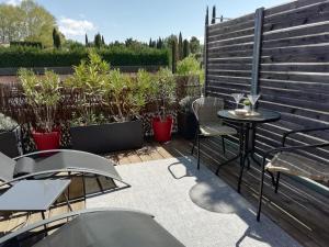 une terrasse avec une table, des chaises et des plantes dans l'établissement Sweet Home studio Aix en Provence, terrasse, piscine, resto,, à Aix-en-Provence