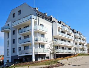 a white building with balconies on the side of it at Apartment 1A in Świnoujście