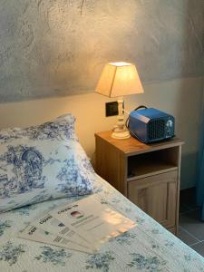a bed with a lamp and a radio on a table at Villa Pille in Monzambano