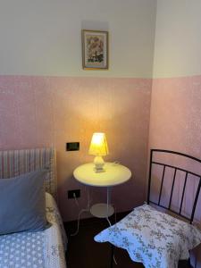 a bedroom with a bed and a table with a lamp at Villa Pille in Monzambano