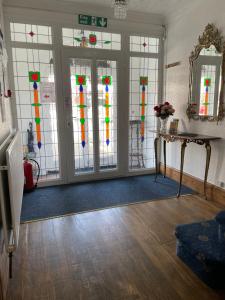 a room with doors with colorful stained glass windows at Whiteways Guest House in Skegness
