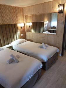 um quarto de hotel com duas camas e um espelho em The Originals Access, Hôtel Foix (P'tit Dej-Hotel) em Foix