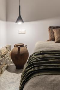um quarto com um vaso grande ao lado de uma cama em Wave, an Idyllic Seafront Suite em Kokkíni Khánion