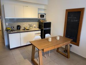 cocina con mesa de madera y nevera negra en Apartamento nuevo en Congreso- amplio- vista inigualable en Buenos Aires