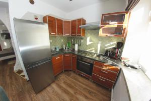 kuchnia z lodówką ze stali nierdzewnej i drewnianymi szafkami w obiekcie Apartament Marcel w mieście Duszniki Zdrój