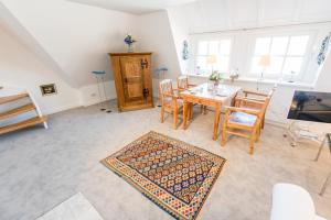 a living room with a dining room table and chairs at Munkmarscher Chaussee 11 Whg 22 in Keitum
