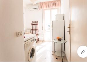 a kitchen with a white refrigerator and a table at Riva dei fiori in Viareggio
