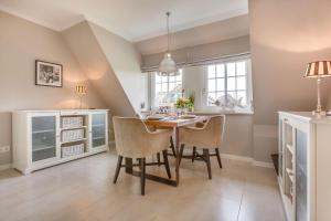 a kitchen and dining room with a table and chairs at Haus Weesterhuk Whg 8 in Keitum
