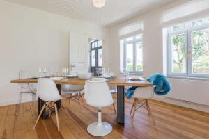 ein Esszimmer mit einem Holztisch und weißen Stühlen in der Unterkunft Hüs Elsbe in Westerland
