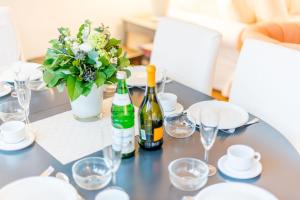 a table with two bottles of wine and a vase of flowers at Inseloase Ostertresker 54 in Tinnum