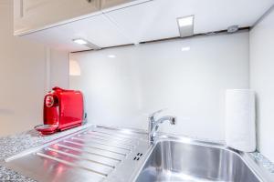 a kitchen with a red toaster sitting on top of a sink at Inseloase Ostertresker 54 in Tinnum