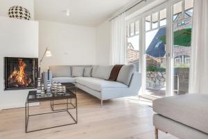 a living room with a couch and a fireplace at Haus Tess in Westerland