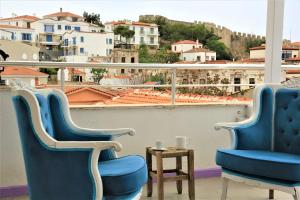 Dos sillas azules y una mesa en un balcón. en Lavender Otel, en Cesme