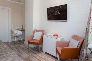 um quarto com duas cadeiras e uma televisão na parede em Haus Doktor Ross Strasse 25 Whg 1 em Westerland