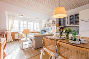 a kitchen and living room with a table and chairs at Haus Neptun Whg 6 in Munkmarsch