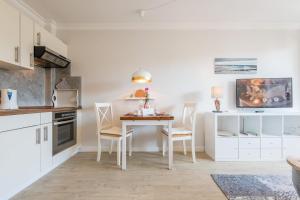 a kitchen with a table and chairs in a room at Haus Christianenhoehe Whg 10 in Westerland (Sylt)
