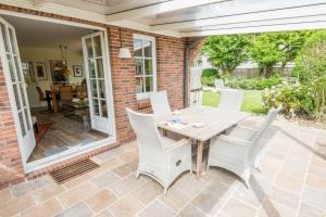 a patio with a wooden table and chairs at Wenningstedter Weg Haushaelfte B in Westerland