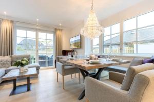ein Esszimmer und ein Wohnzimmer mit Tisch und Stühlen in der Unterkunft Süster Hüs in Westerland