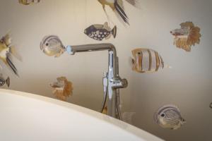 ein Badezimmer mit einer Dusche mit Fischdecalen an der Wand in der Unterkunft Süster Hüs in Westerland + 36 Fotos