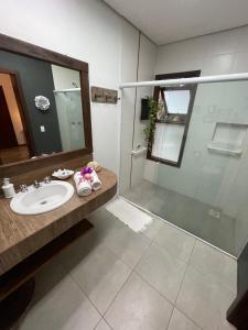 a bathroom with a sink and a shower at Pousada Santarina in Florianópolis