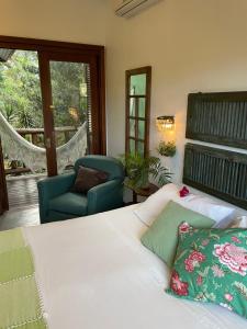 a bedroom with a bed and a chair and a window at Pousada Santarina in Florianópolis