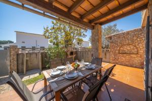 a wooden table and chairs on a patio at Villa Paulina in Sant Martí d'Empúries