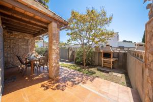 an outdoor patio with a table and a grill at Villa Paulina in Sant Martí d'Empúries