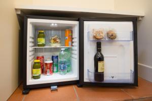 einen offenen Kühlschrank mit einer Flasche Wein in der Unterkunft Hotel Il Duomo in Assisi