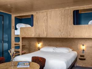a bedroom with a bed and two bunk beds at Eklo Marne La Vallée in Serris