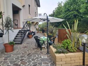 a patio with a table and an umbrella at Hotel La Passeggiata in Desenzano del Garda