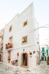 a white building on a street with a red bike in front at B&B Borgo San Martino in Monopoli
