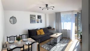 een woonkamer met een bank en een tafel bij Apartament Mineralny in Krynica Zdrój